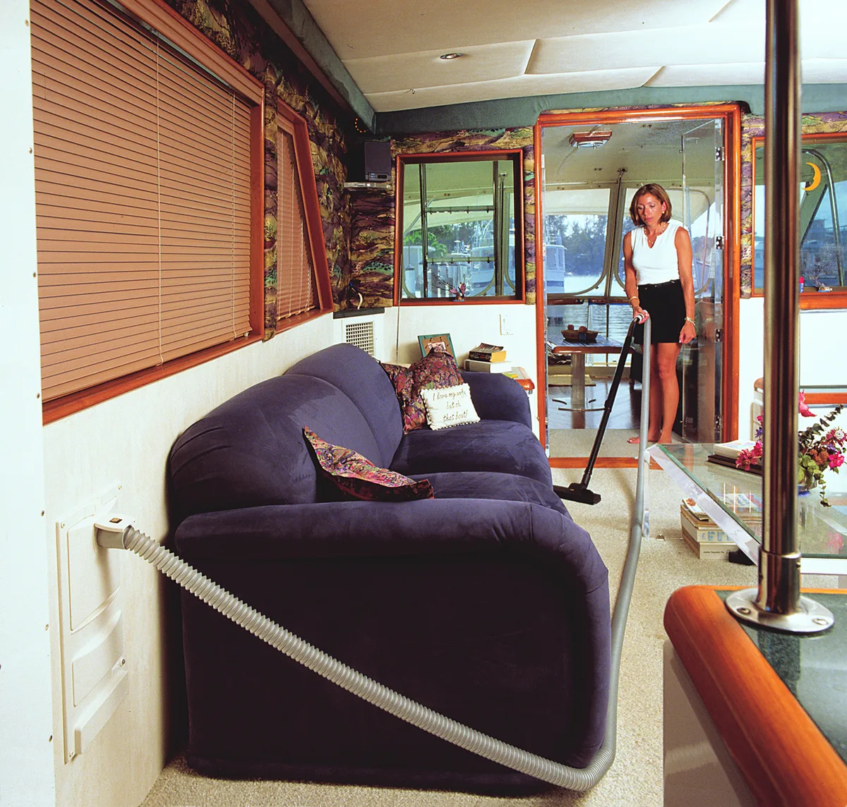 Cleaning the salon. The hose plugs into a wall inlet and reaches across the salon. No machine to carry up the companionway.